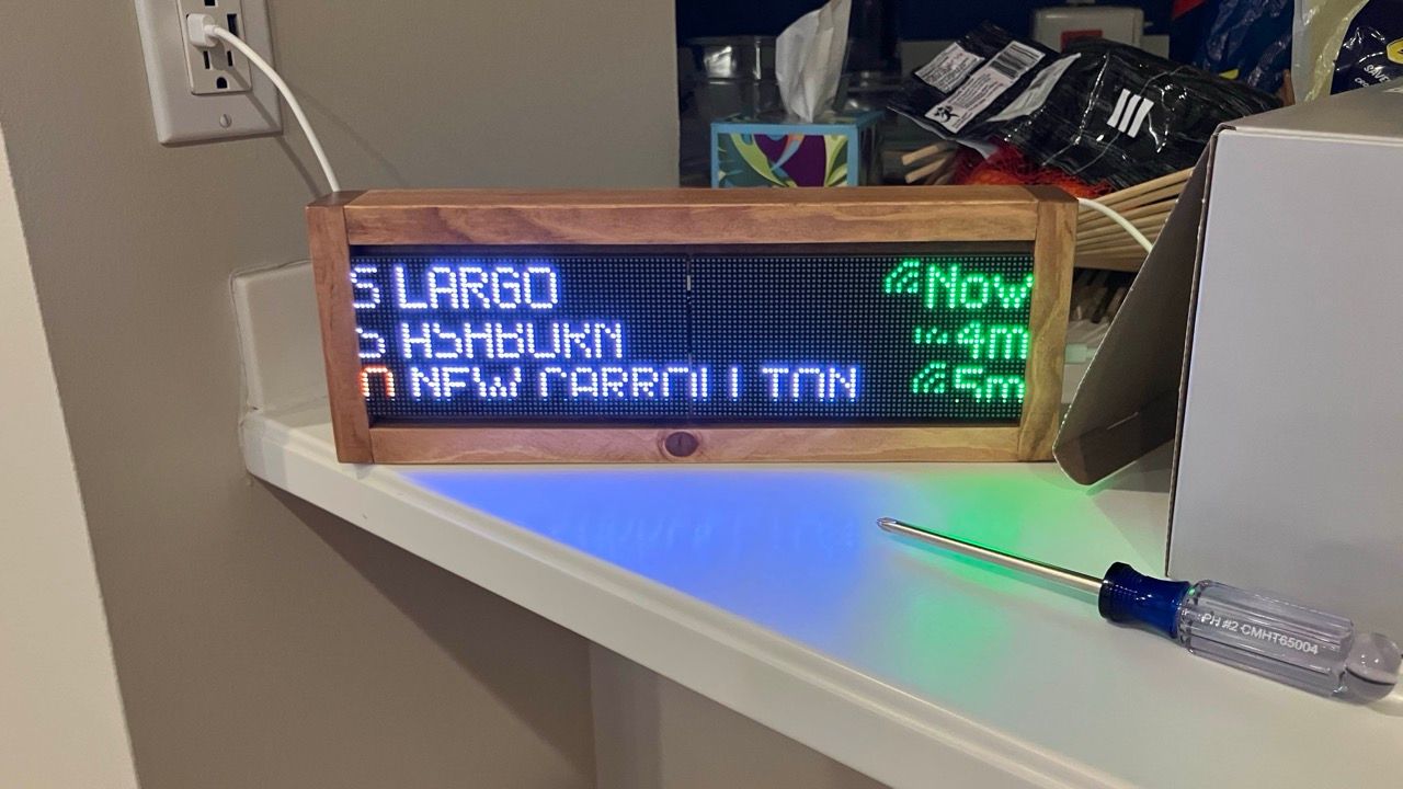 A Transit Tracker with a brown wooden frame on a table.
