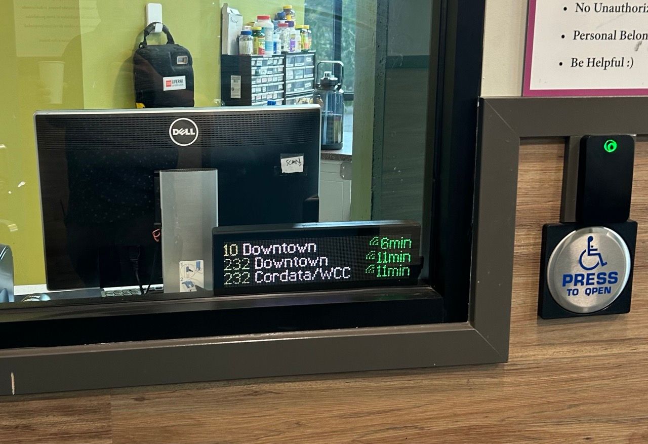 A Transit Tracker in the window at a front desk. A computer monitor can be seen behind the Transit Tracker.